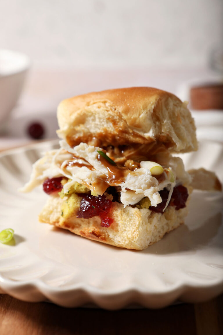 Close up of a Turkey Cranberry Sandwich on a beige plate