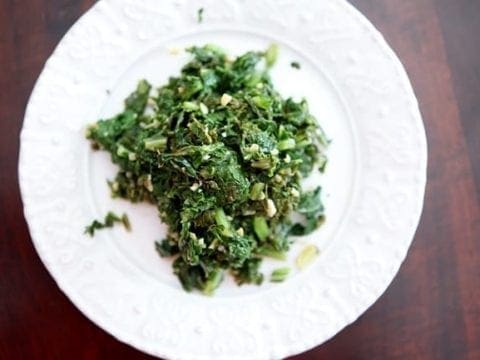 Overhead view of sautéed greens on white plate 