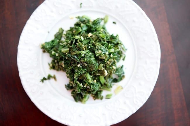 Overhead view of sautéed greens on white plate 