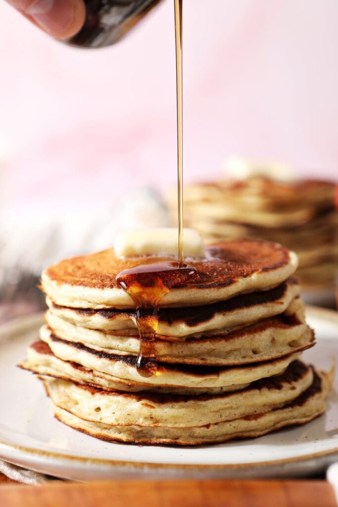 Maple syrup pours on top of oatmeal pancakes