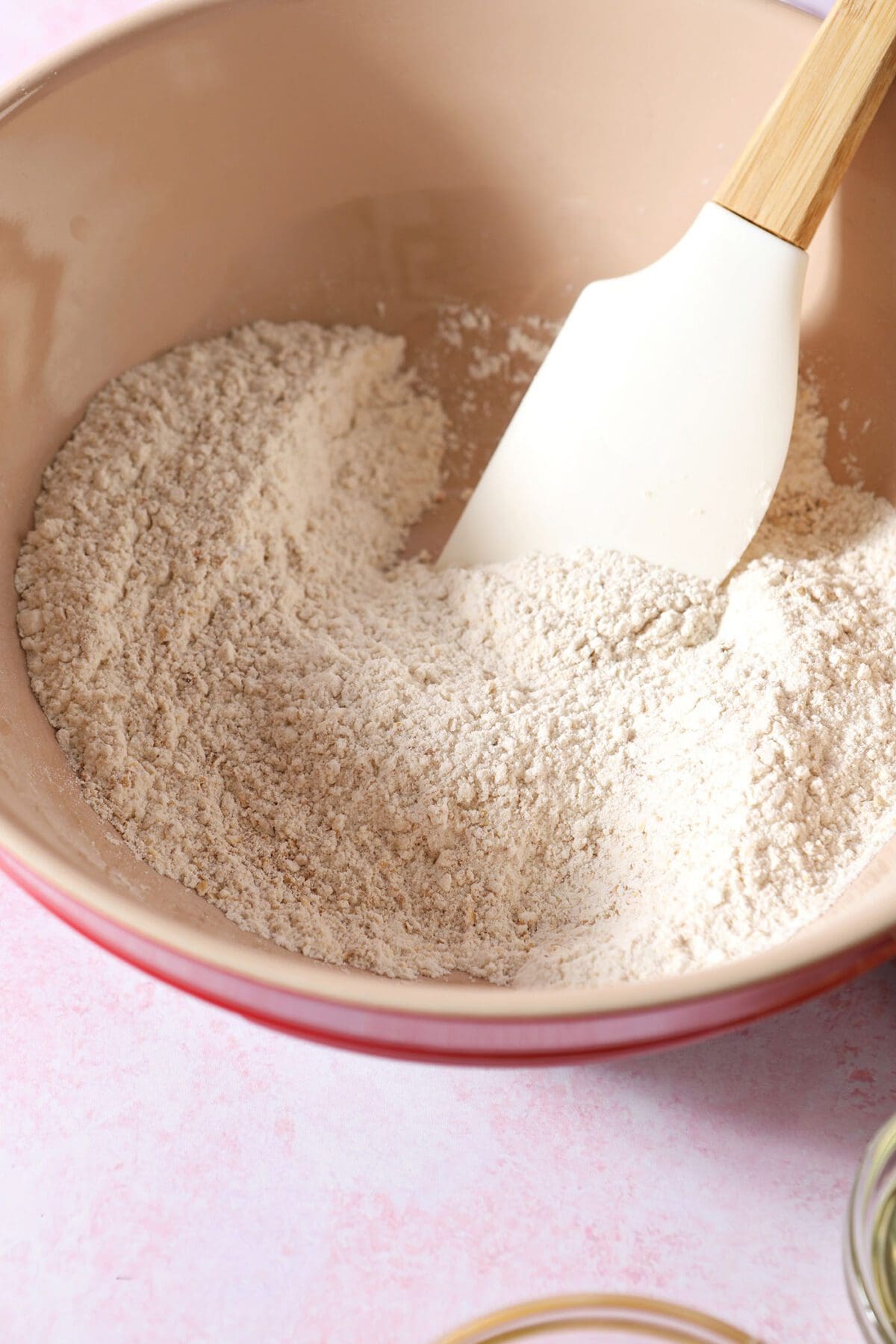 Dry ingredients in a bowl with a rubber spatula