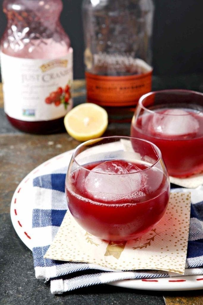 Two Blizzard Bourbon Cranberry Cocktails sit on a platter, ready for drinking