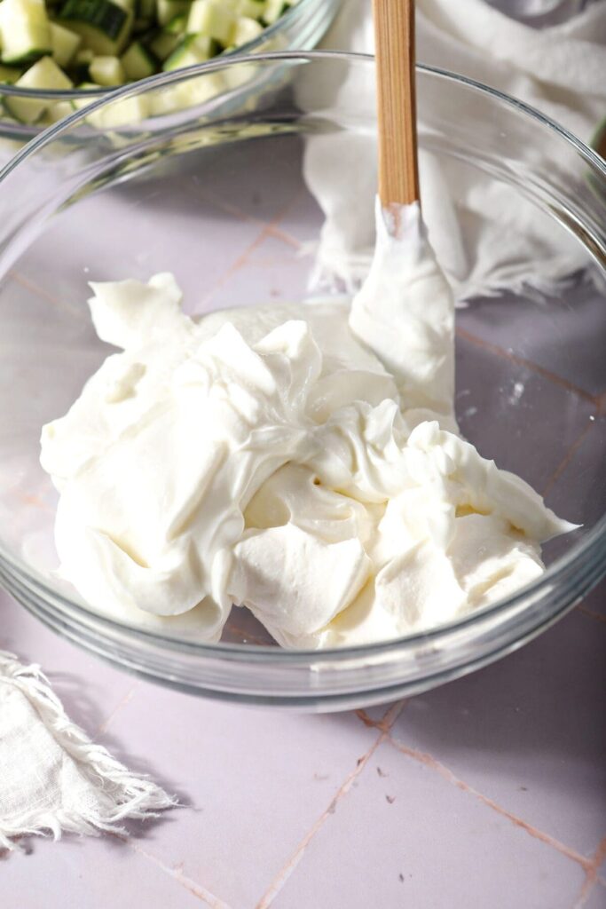 Sour cream and greek yogurt in a bowl on a purple surface