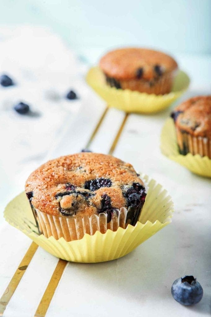 Vegan Blueberry Muffins, on a marble serving board, are ready for eating.