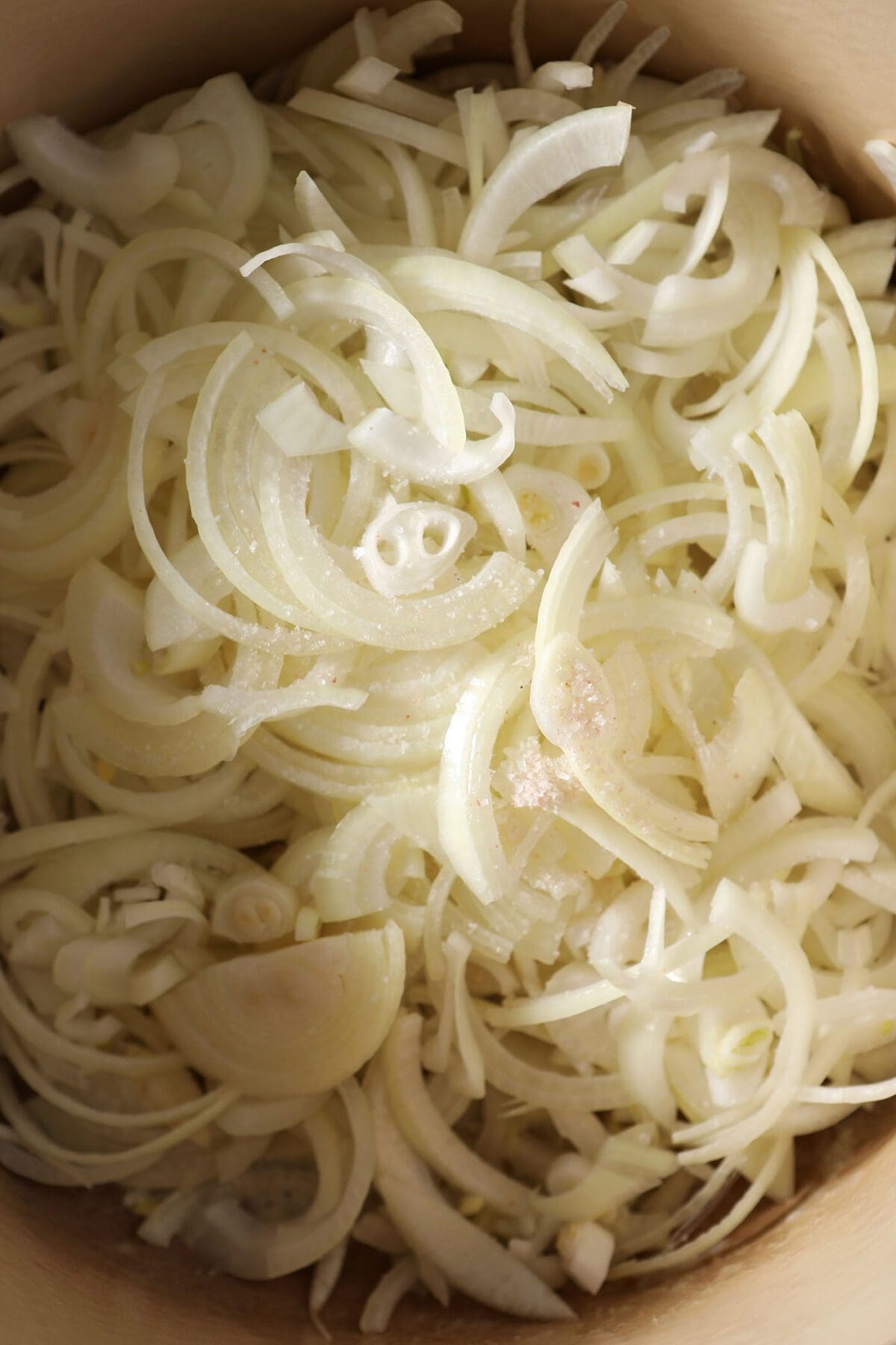 Close up of thinly sliced onions in a Dutch Oven