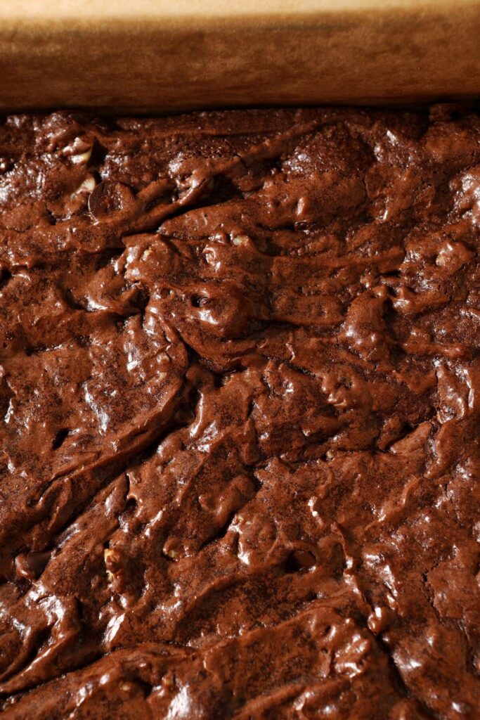 The crackly top of brownies in a pan before slicing