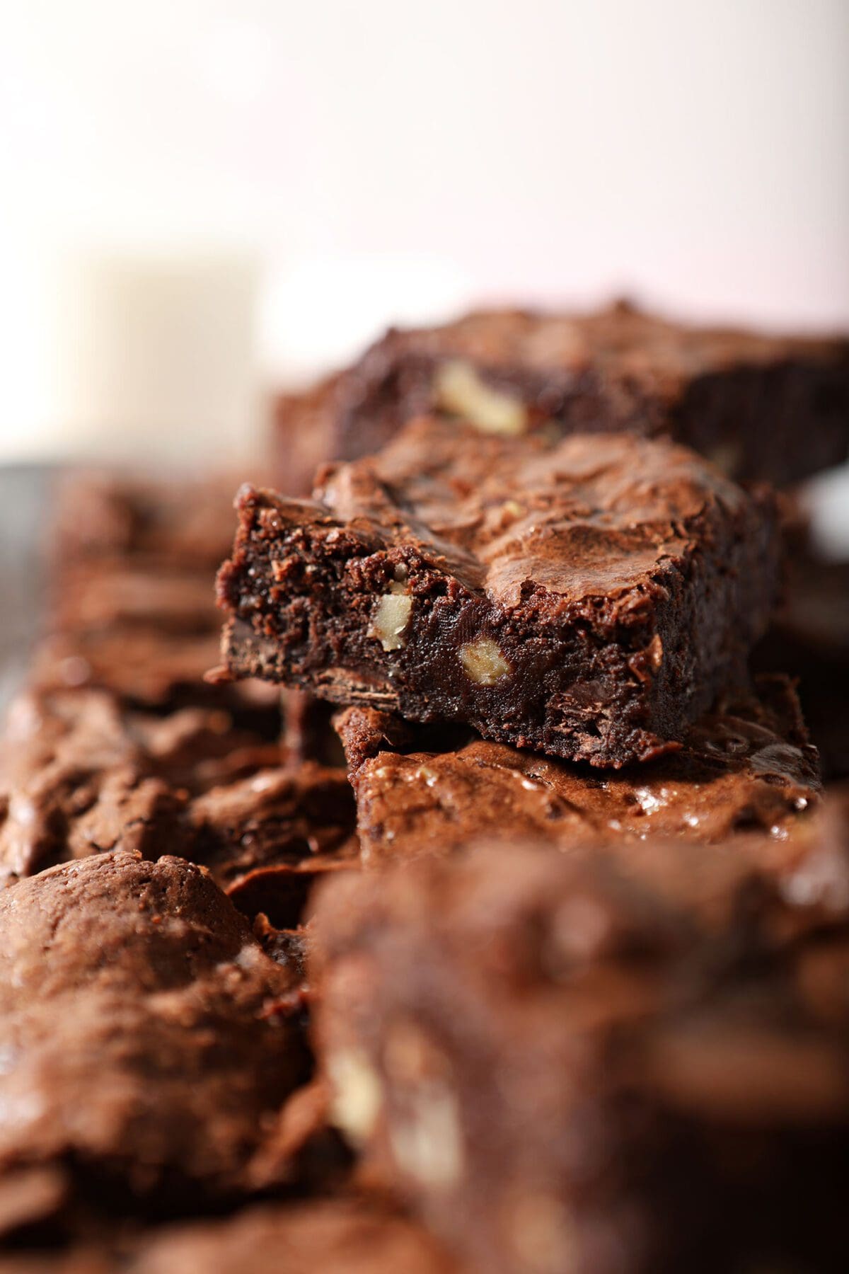 Brownies stacked on top of each other on a plate with nuts