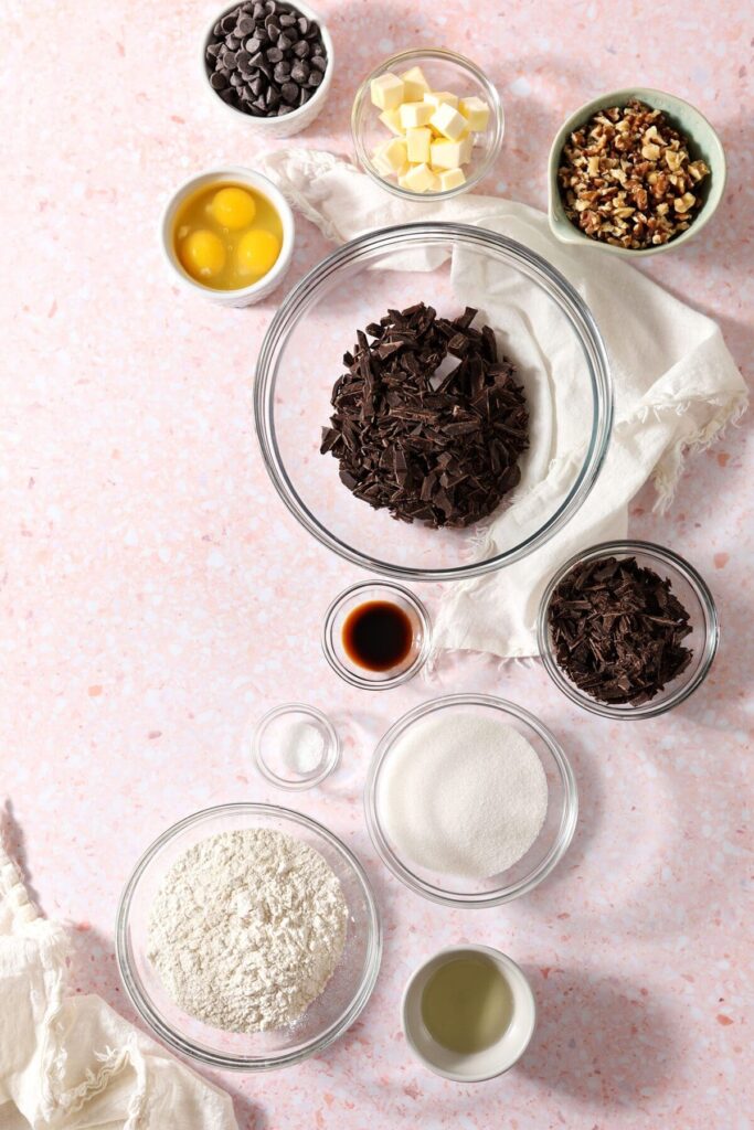 Ingredients to make brownies in bowls on a pink terrazzo countertop