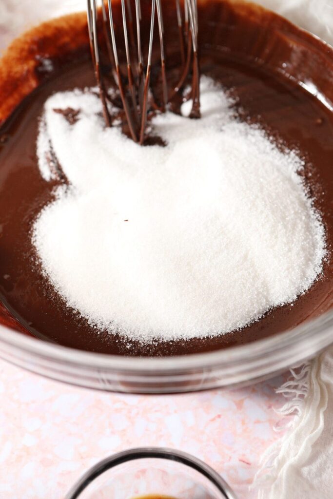 Sugar in a bowl on top of melted chocolate mixture