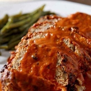 Close up of sliced Slow Cooker Turkey Meatloaf, smothered in tomato sauce, before serving