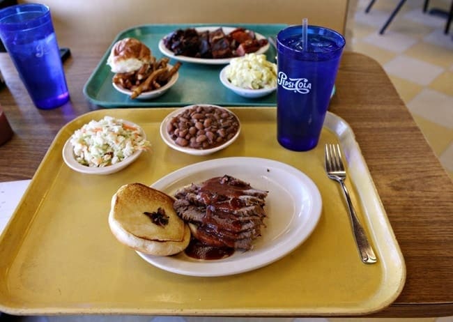 Two trays of food and beverage on table 