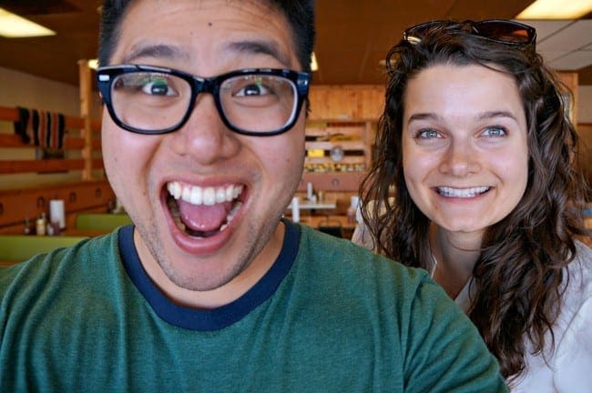 A man in glasses and a brunette woman smile for the camera