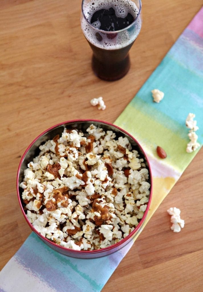 Overhead view of popcorn in bowl on linens next to beverage 