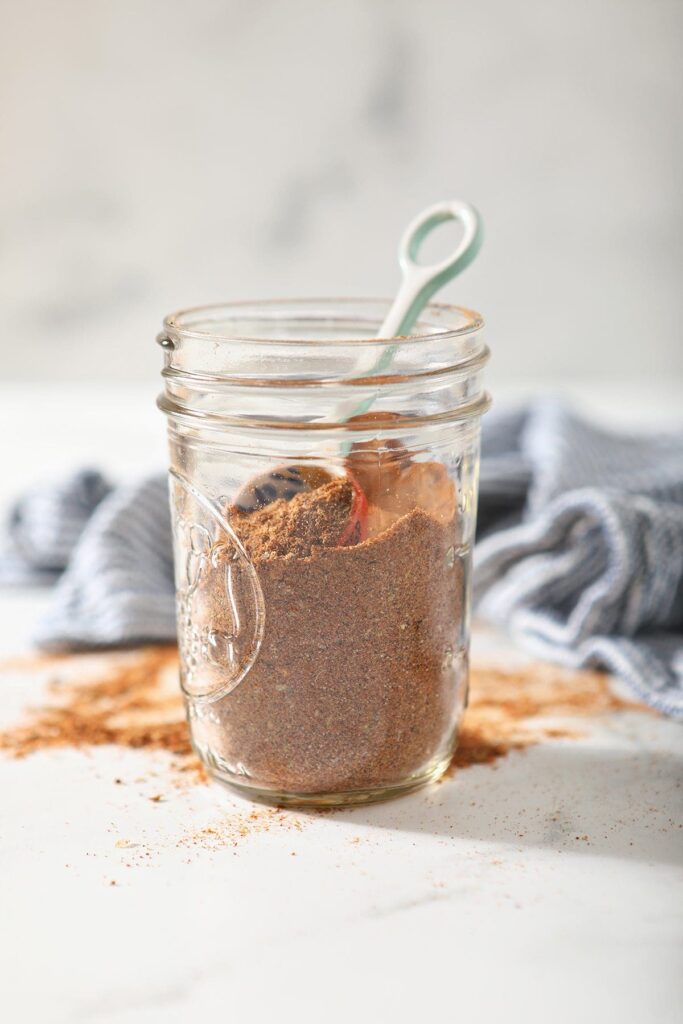 A jar of DIY taco seasoning on marble