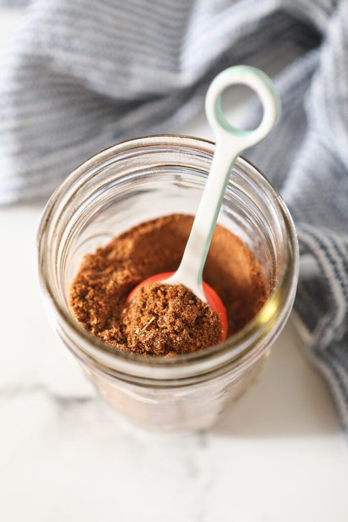 A spoon in a jar of taco spice mix