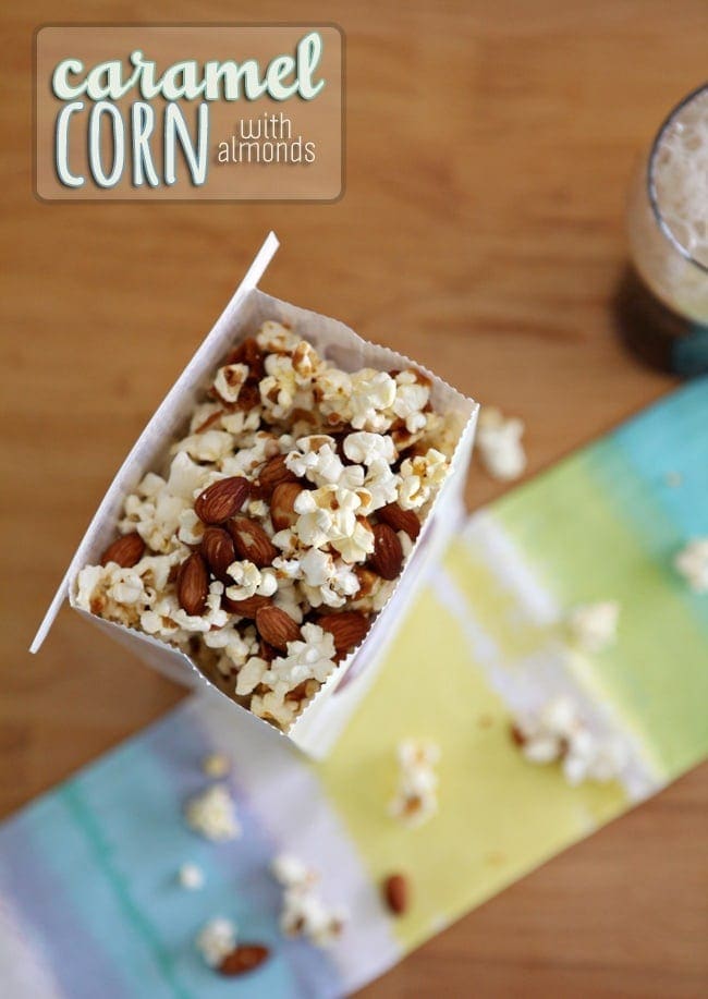 Caramel Corn with Almonds in a white bag on top of linens 