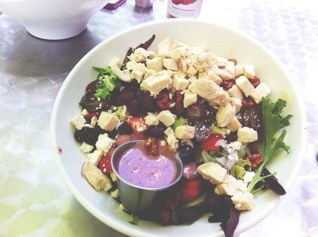 A white bowl holds a colorful salad