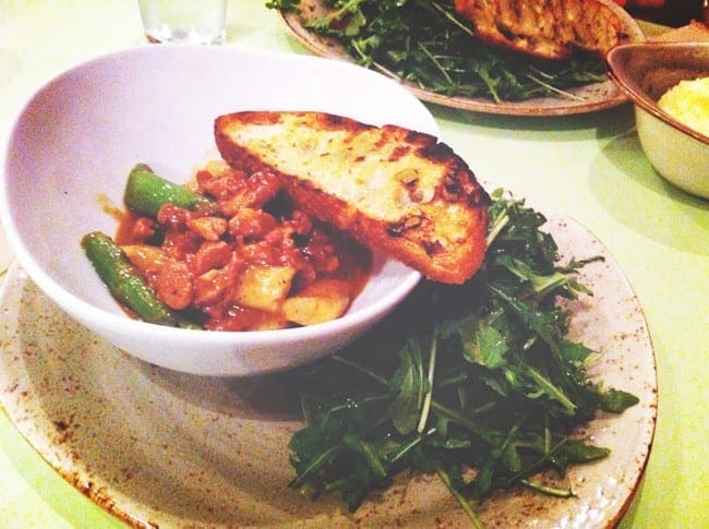 A bowl of pasta in a red sauce with asparagus