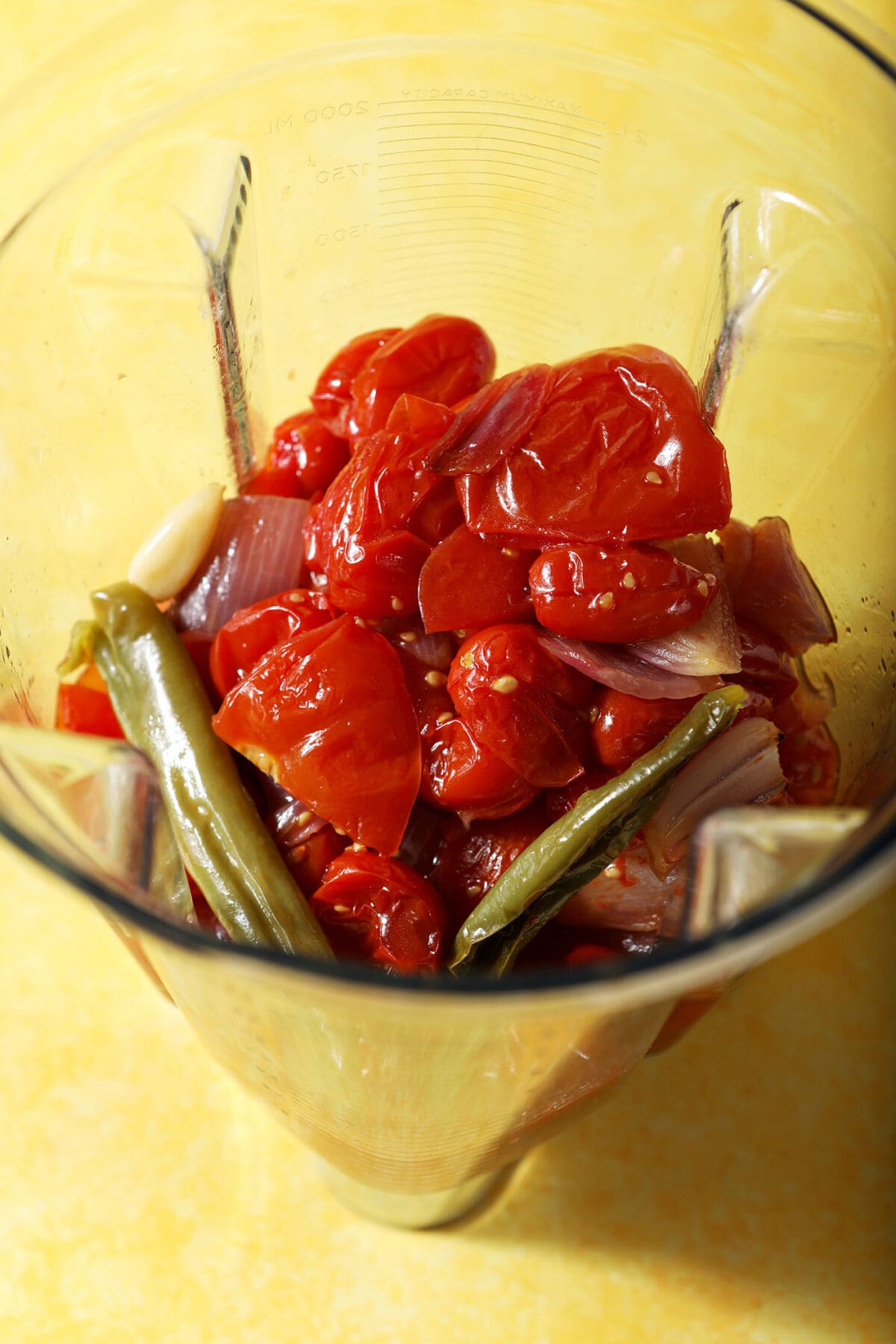 Roasted tomatoes and other ingredients to make salsa in a blender
