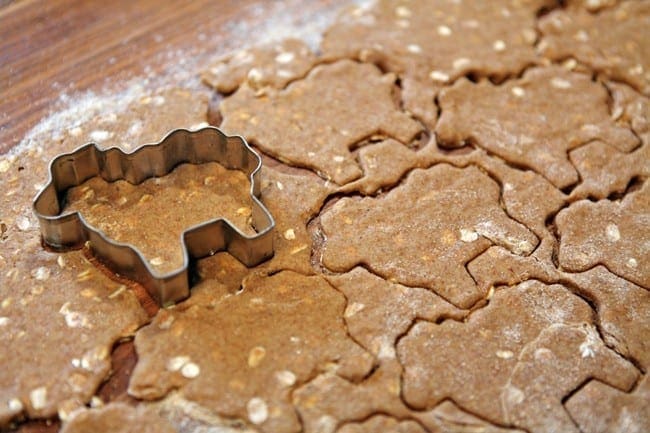 Close up of dog shaped cookie cutter, cutting into dough 