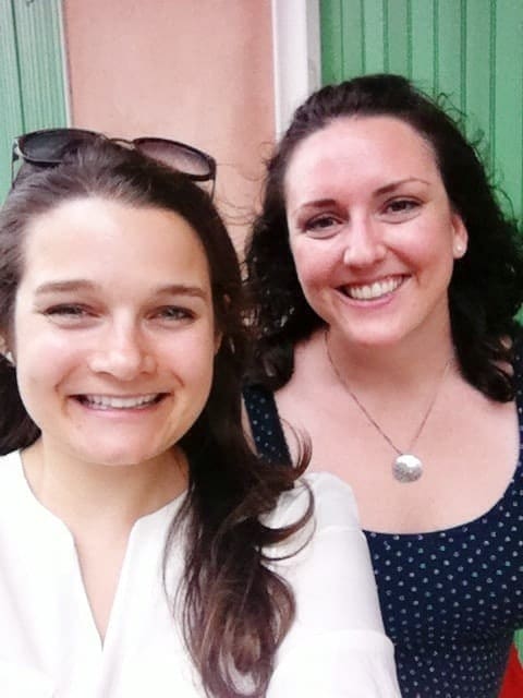 Two light-skinned, dark-haired women smile at the camera