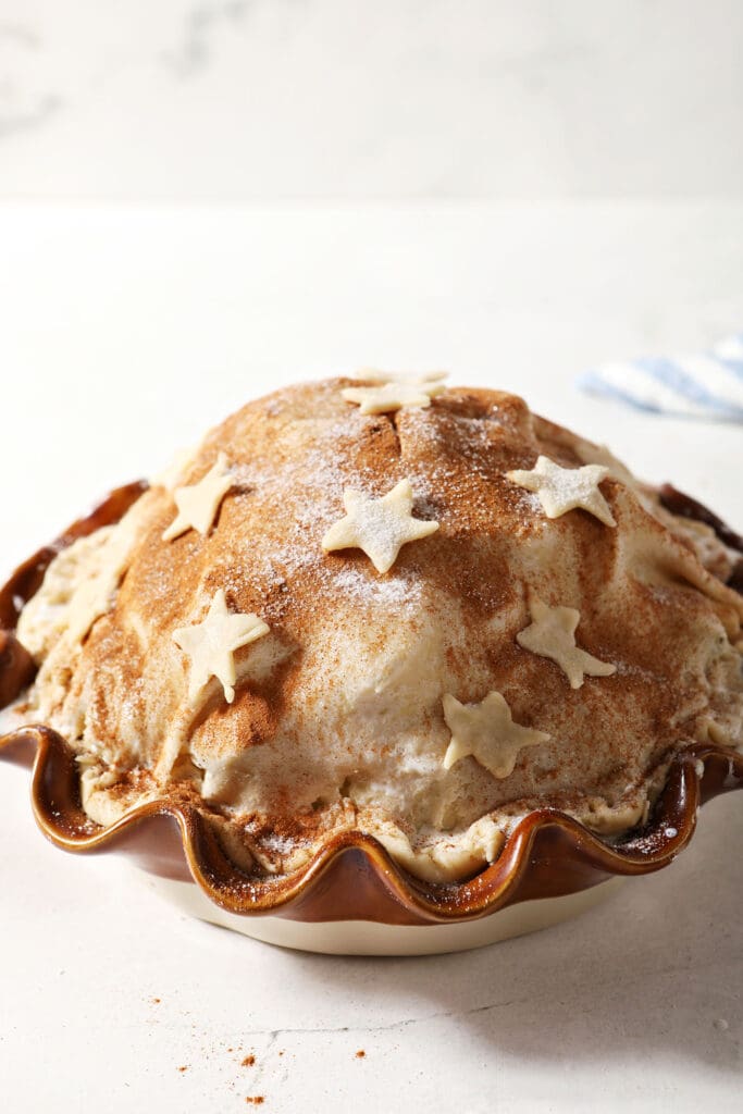 Cut out stars sit on top of raw pie crust, before the pie bakes