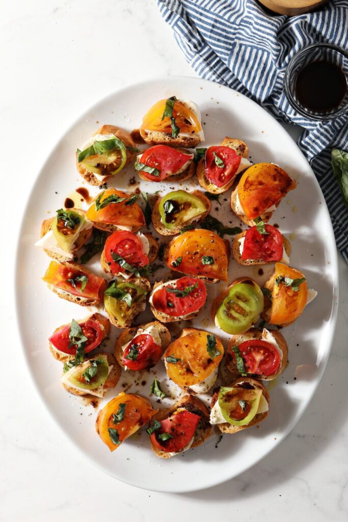 A oval platter of Caprese Bruschetta with Heirloom Tomatoes