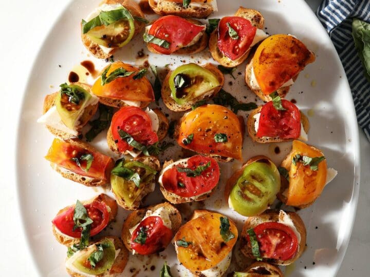 A oval platter of Caprese Bruschetta with Heirloom Tomatoes