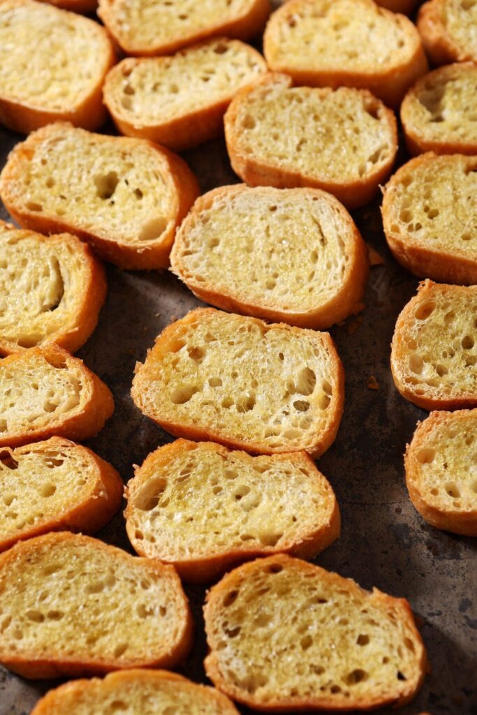 Toasted baguette rounds on a sheet pan