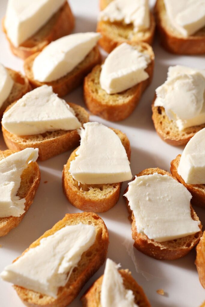 Sliced buffalo mozzarella on toasted baguettes on a white platter