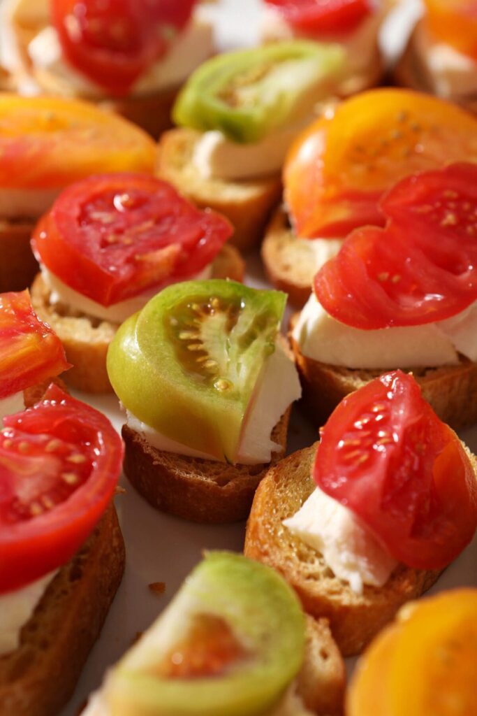 Heirloom tomato slices on top of buffalo mozzarella and toasted baguettes