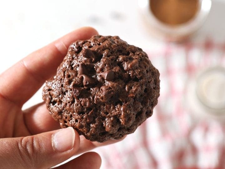 A woman holds a Chocolate Almond Butter Cookies with Chocolate Chips in her hand