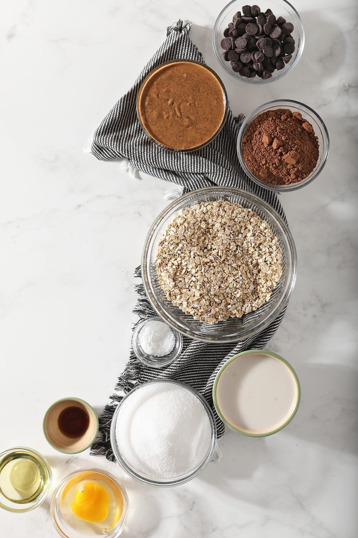 Overhead image of the ingredients for gluten free cookies on a gray and white striped towel