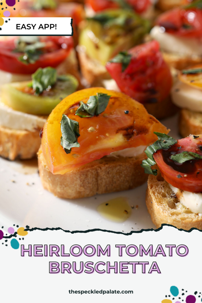 Close up of several Caprese Bruschetta with Heirloom Tomatoes on a white platter with the text Heirloom Tomato Bruschetta