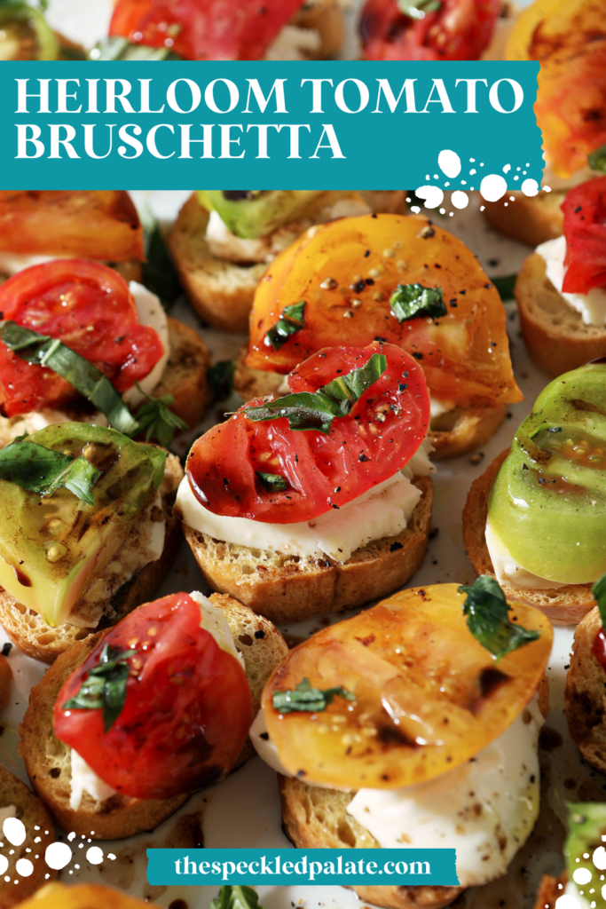 A platter of red, yellow and green tomatoes on bruschetta with the text heirloom tomato bruschetta