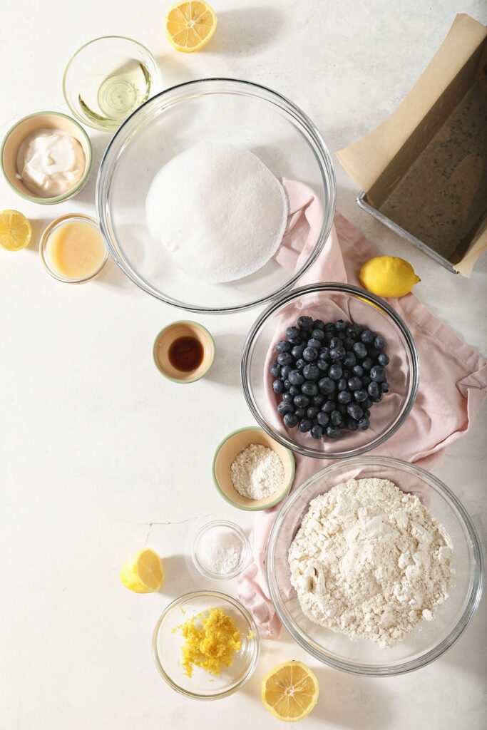 Ingredients for Lemon Blueberry Quick Bread recipe in bowls on marble