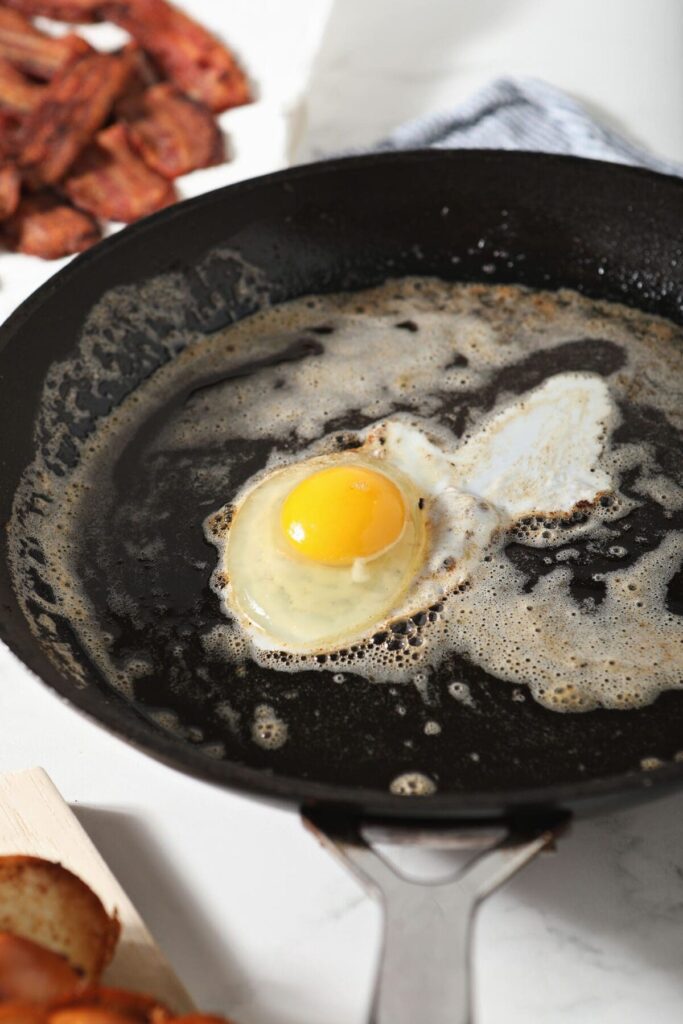 An egg frying in butter in a skillet