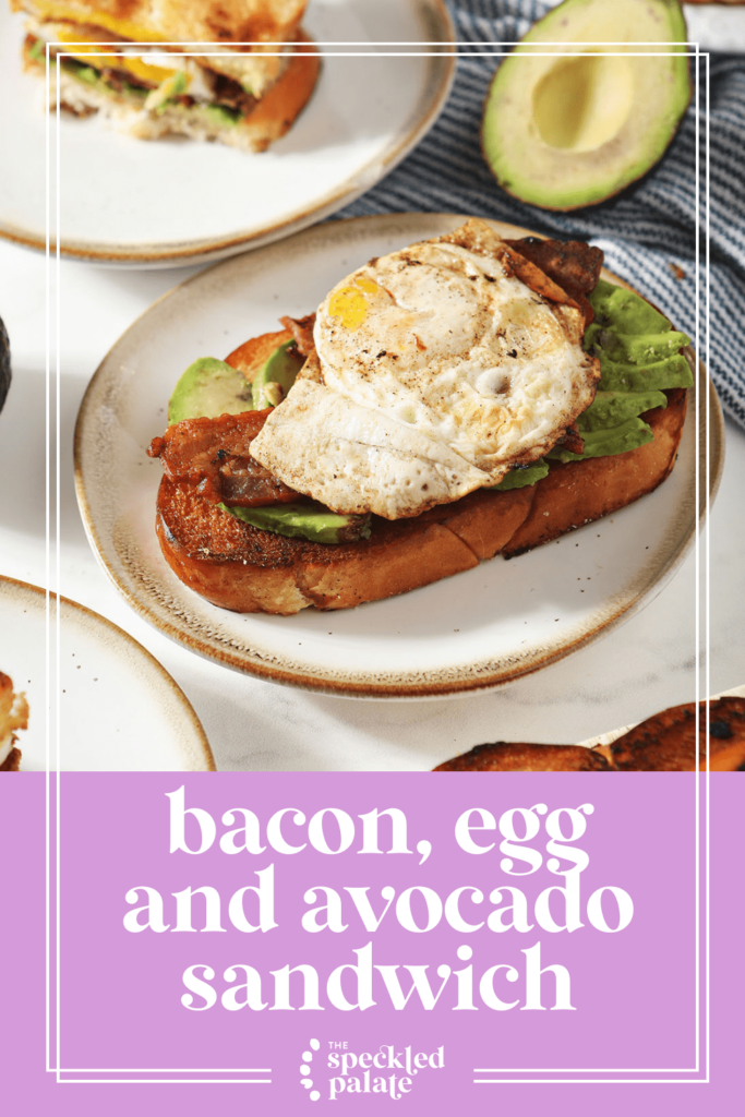 Open-faced breakfast sandwiches on small plates with egg, bacon and avocado with the text bacon, egg and avocado sandwich