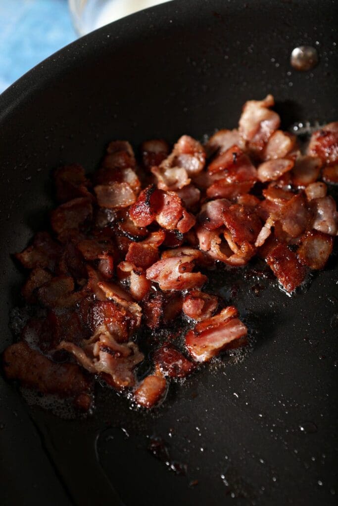 Chopped bacon cooking in a skillet