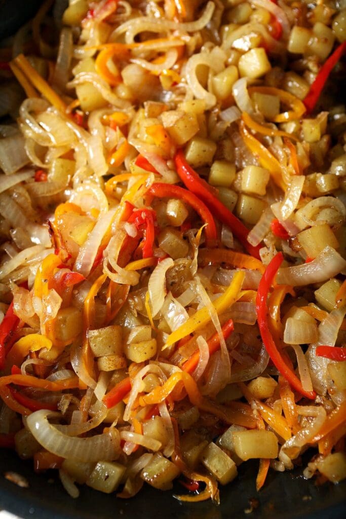 Cooked potatoes, peppers and onions in a skillet