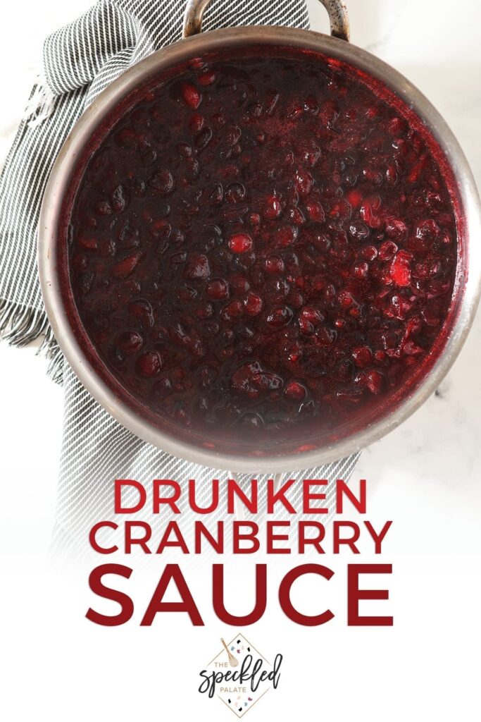 Hot cranberry sauce in a skillet on top of a gray striped towel with the text 'drunken cranberry sauce'