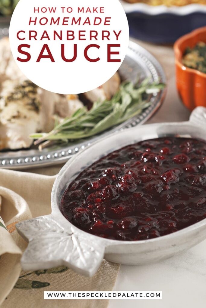 Cranberry sauce in a silver bowl with leafs on the ends next to a silver platter of turkey with the text 'how to make homemade cranberry sauce'