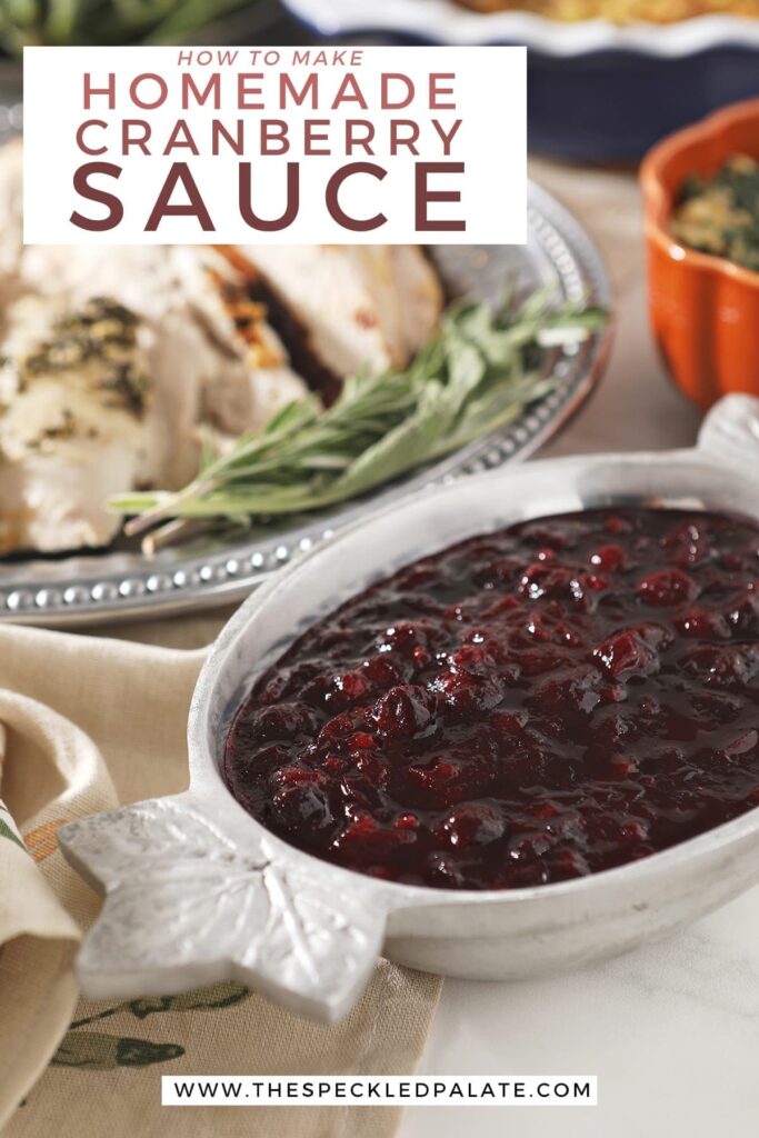 Cranberry sauce in a silver bowl with leafs on the ends next to a silver platter of turkey with the text 'how to make homemade cranberry sauce'