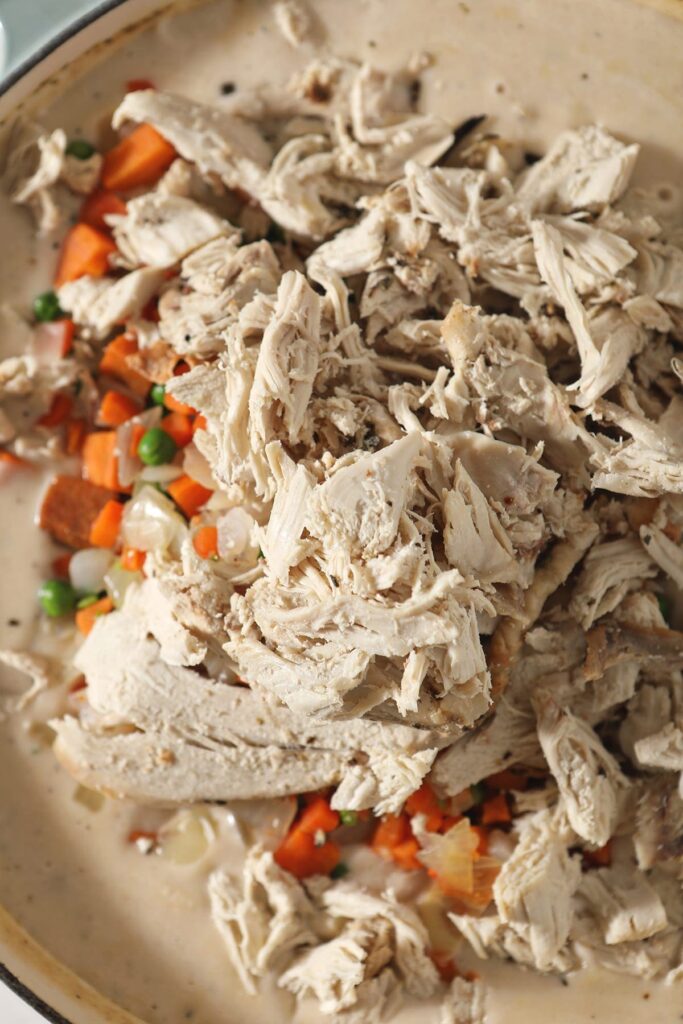 Close up of leftover shredded turkey, vegetables and the pot pie liquid before stirring