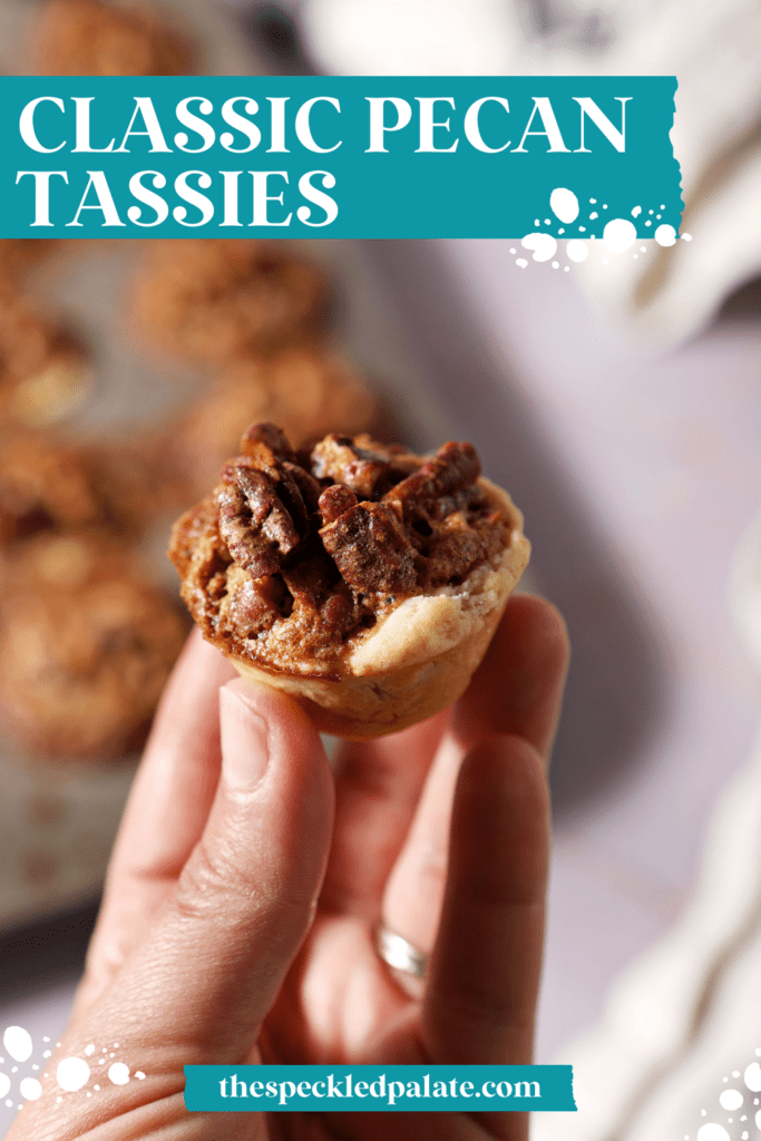 a hand holds a pecan tassie above a mini muffin tin of more tassies on a purple surface with the text classic pecan tassies