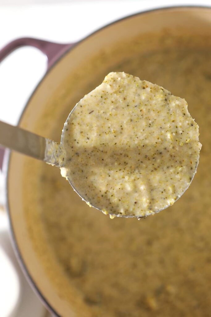 A metal ladle holds a scoop of Easy Broccoli Cheddar Soup