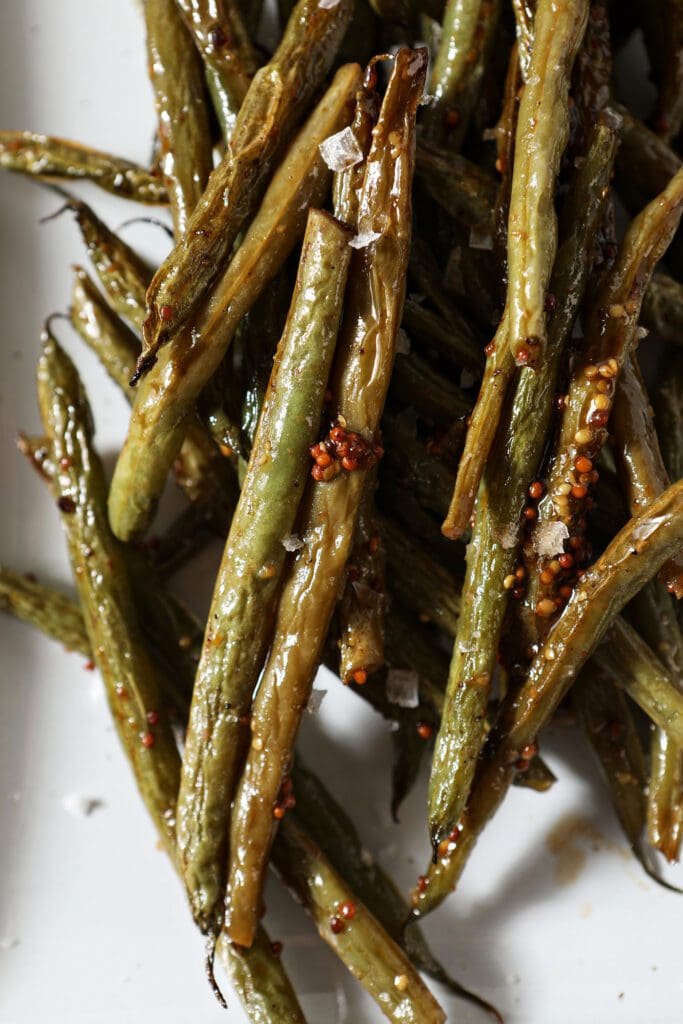 Close up of roasted green beans in a sauce