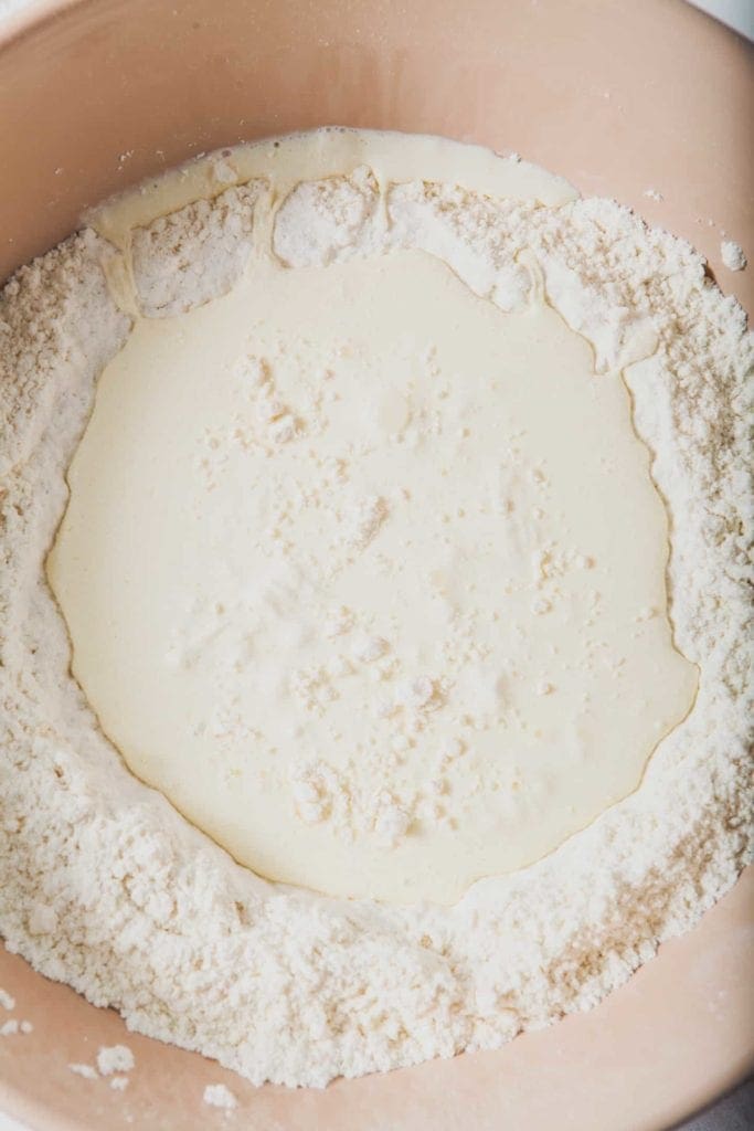 The dough for Cream Biscuits is mixed together in a large glass bowl