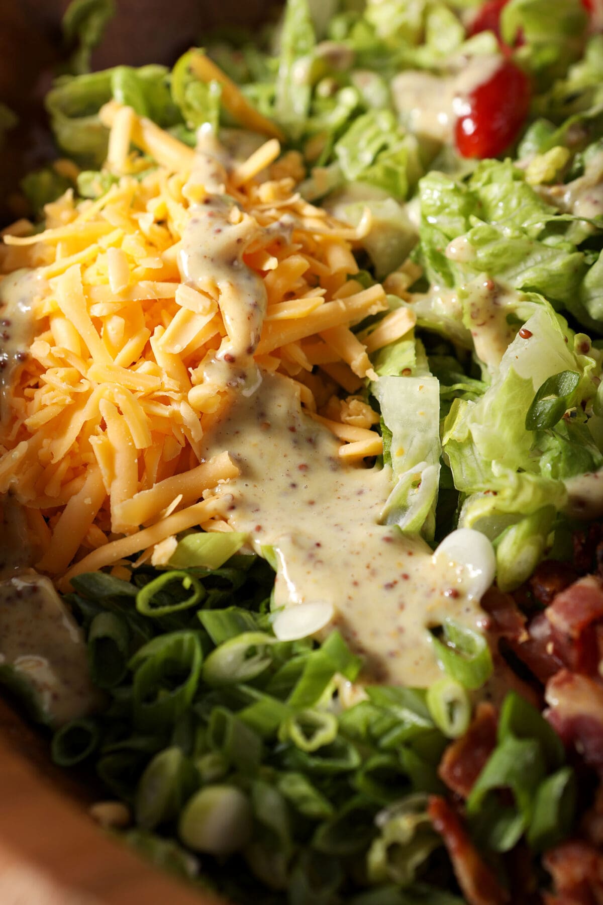 honey mustard dressing on top of salad ingredients in a bowl