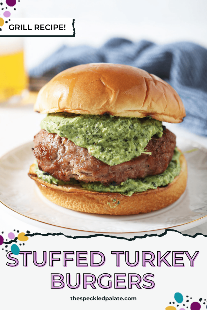 A grilled turkey burger stuffed with spinach artichoke filling on a plate with the text Stuffed Turkey Burgers Grill Recipe